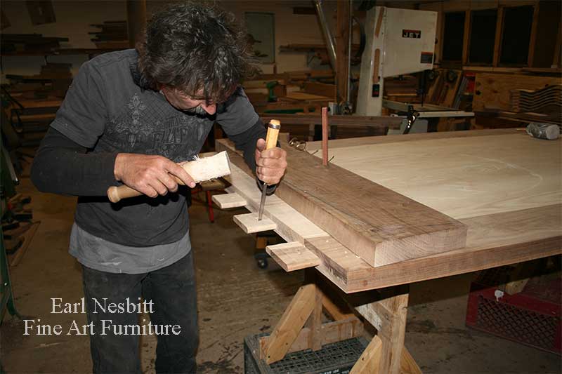 Earl pegging tenons of a custom made dining table showing tenons Earl pegging tenons of a custom made dining table showing tenons